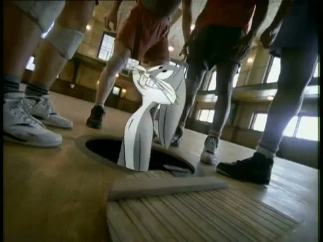 Bugs Bunny emerges from a hole in a wooden basketball court, surrounded by the legs of several male basketball players.
