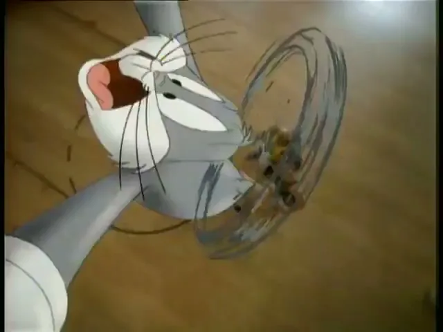 Bugs Bunny, a grey rabbit, is spun around by a group of basketball players on a court.