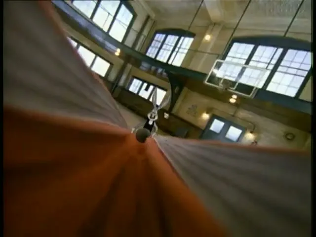Bugs Bunny, a grey and white cartoon rabbit, is seen from a POV shot as he dunks a basketball into a hoop in a school gym.