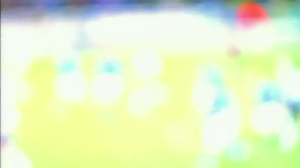 A blurry, out-of-focus shot of a soccer field with indistinct figures in blue and white jerseys, suggesting a game in progress.