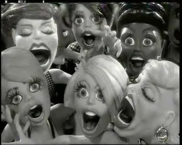 A group of stylized, screaming female dolls with exaggerated features are shown in black and white, looking distressed.