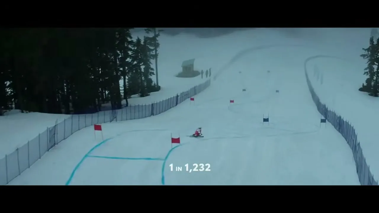 A female skier in a red and white suit races down a snowy mountain slope, passing red and blue flags, with a numerical overlay.