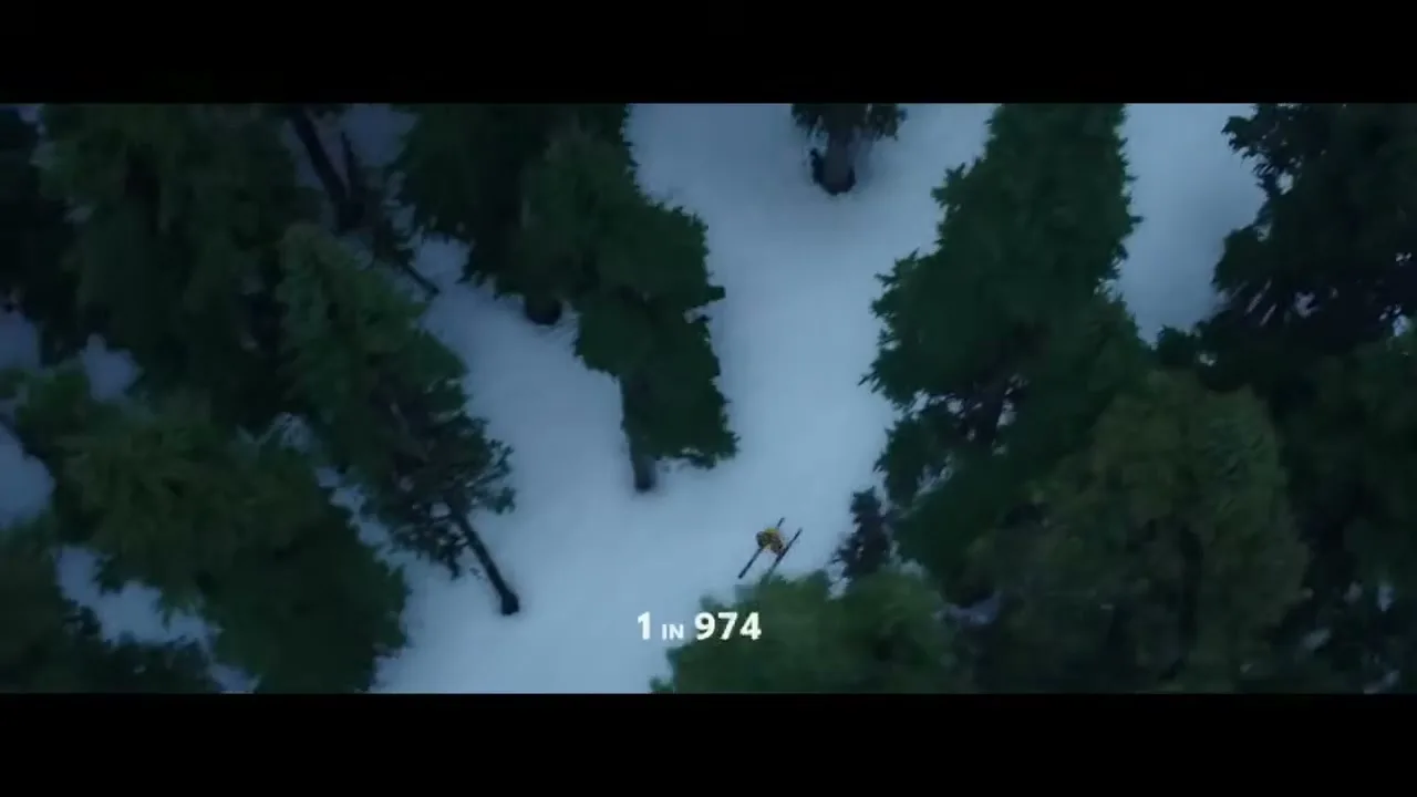 An aerial shot shows a lone skier in yellow and black ski suit, skiing down a snowy slope surrounded by pine trees, with text overlay.