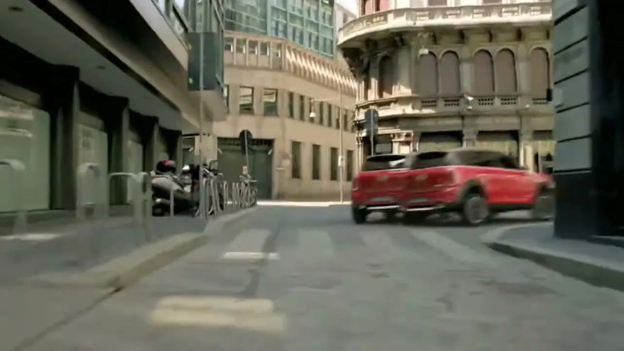 A red Mini Countryman drives down a city street, then multiplies into several identical cars that turn a corner.