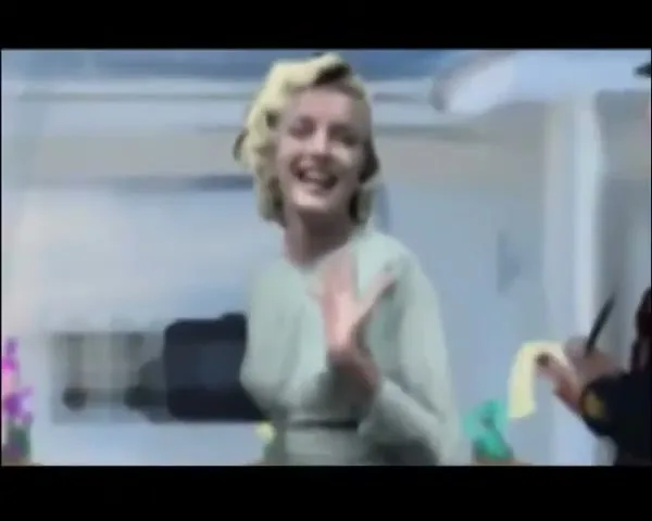 Marilyn Monroe, in a light green dress, waves and laughs while a police officer writes on a notepad in a painted suburban street scene.