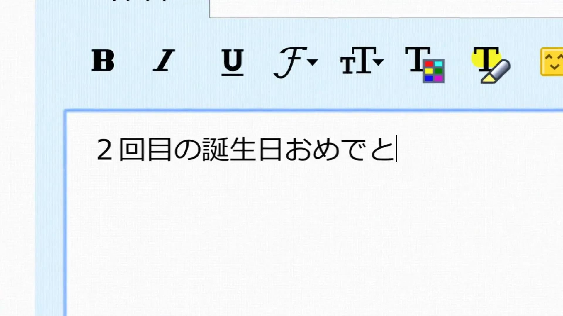 A close-up shot shows a computer screen with a text editor where Japanese characters are being typed, wishing someone a happy second birthday.