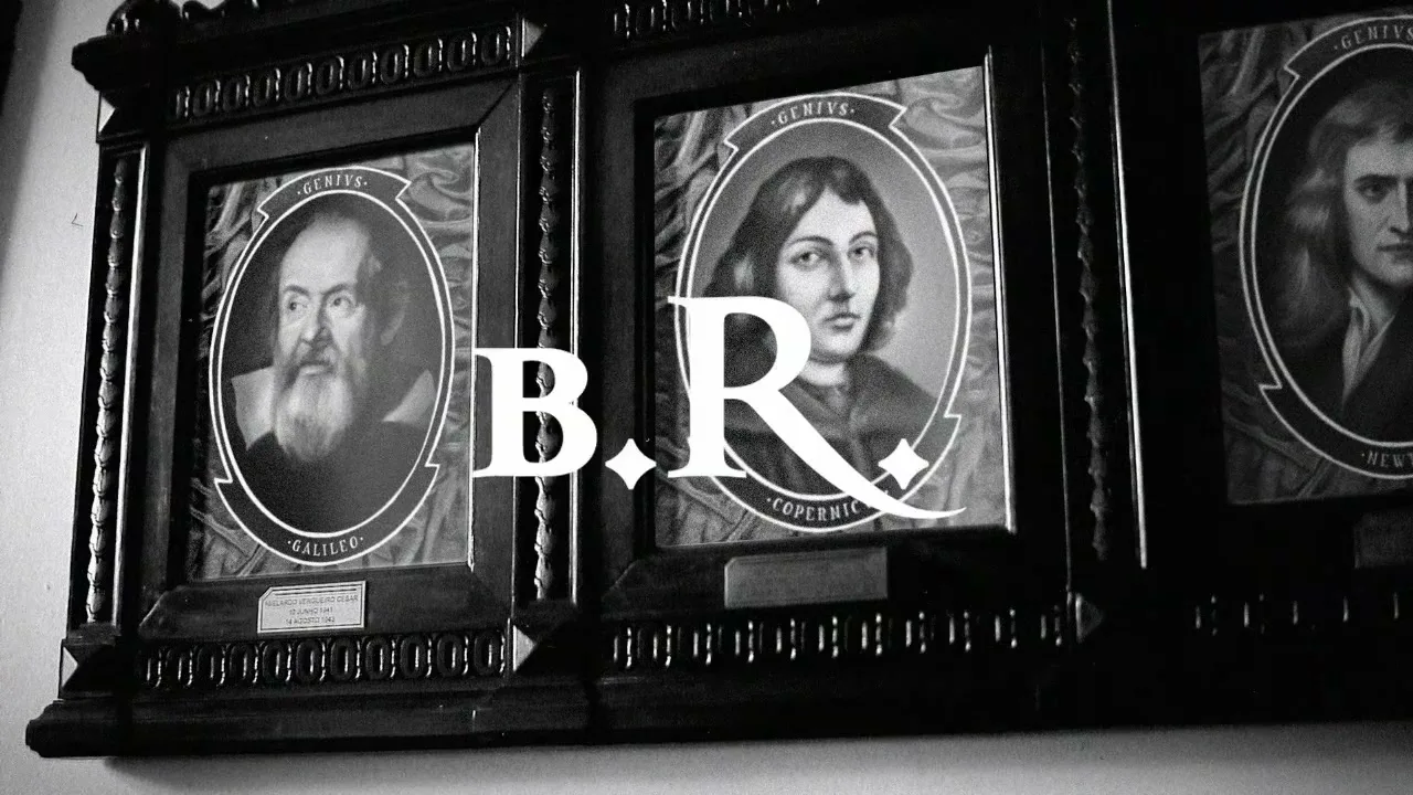 Three framed portraits of historical figures, Galileo, Copernicus, and Newton, are displayed on a wall in a black and white shot.