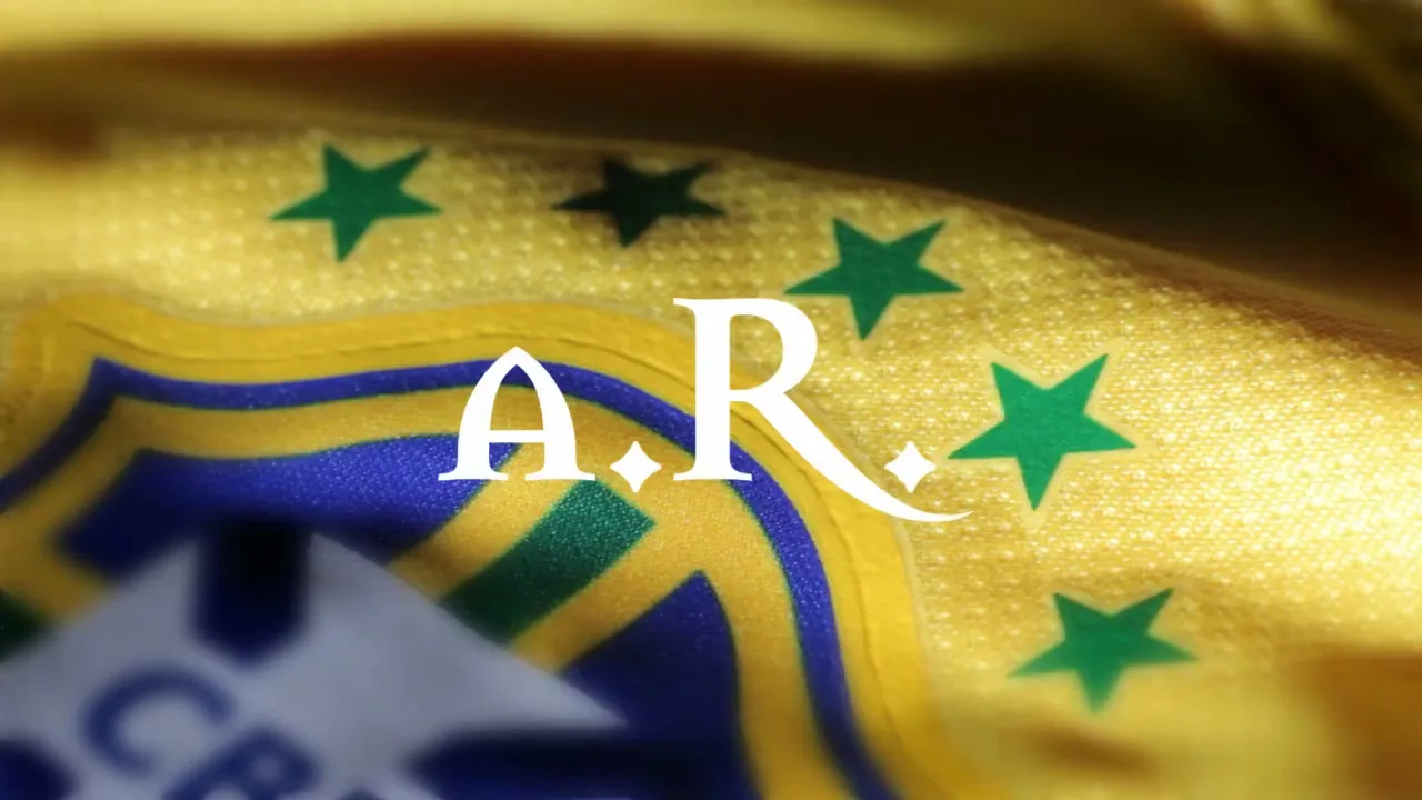 A close-up shot of a yellow fabric with green stars and blue and yellow emblem, possibly a sports jersey, with the letters "A.R." superimposed.