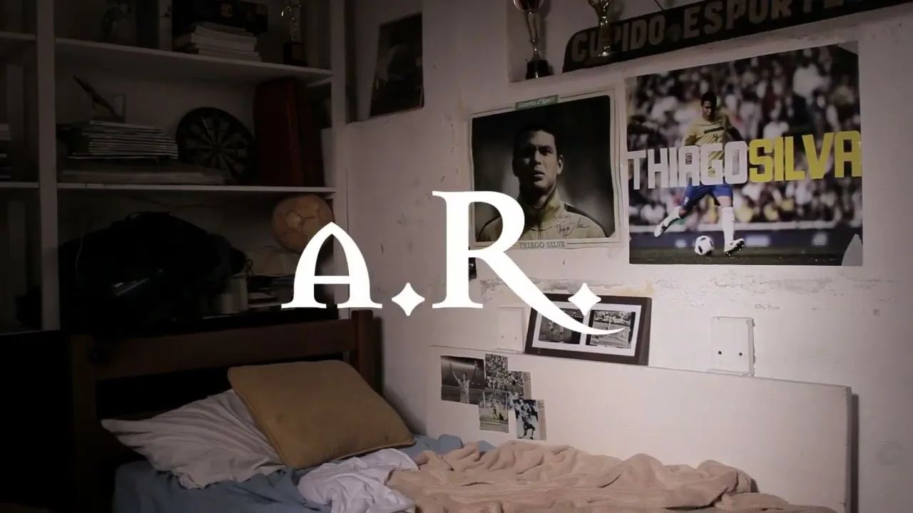 A wide shot of a messy bedroom with a bed, shelves, and posters of soccer players on the wall.