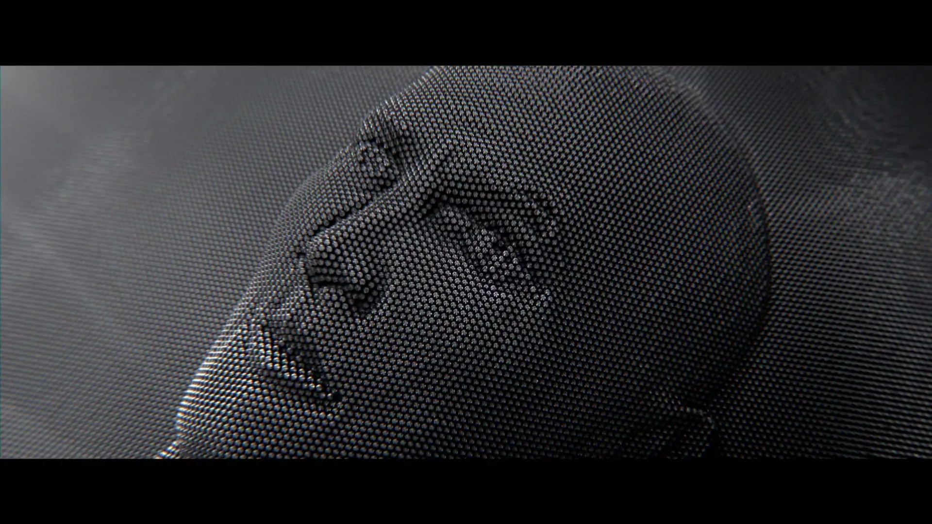 A human face made of pins emerges from a pin art board, then opens its mouth to scream, as a megaphone appears next to it.