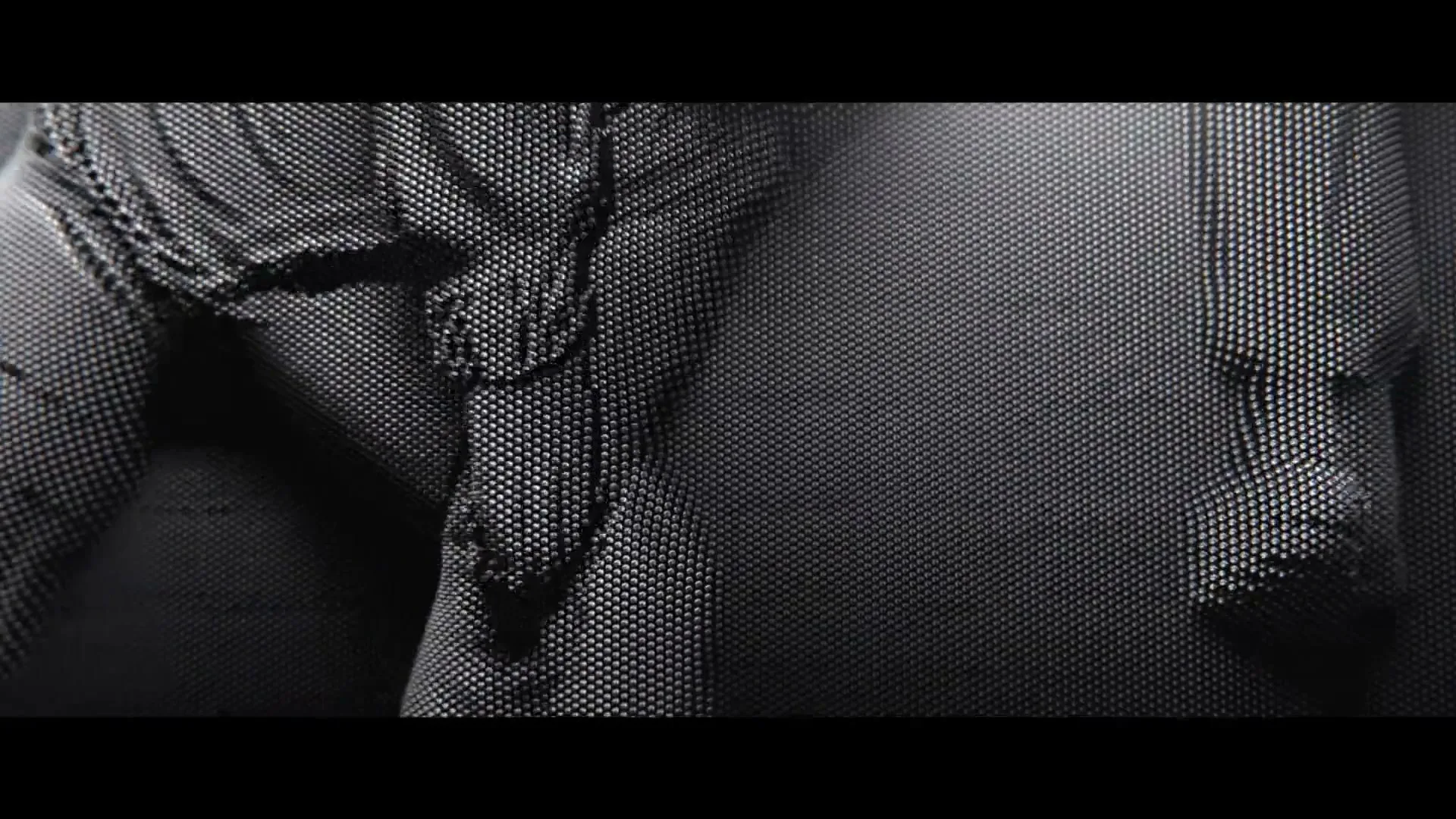 A close-up shot of a person's body, rendered in a pin art style, slowly collapsing and deforming on a dark surface.