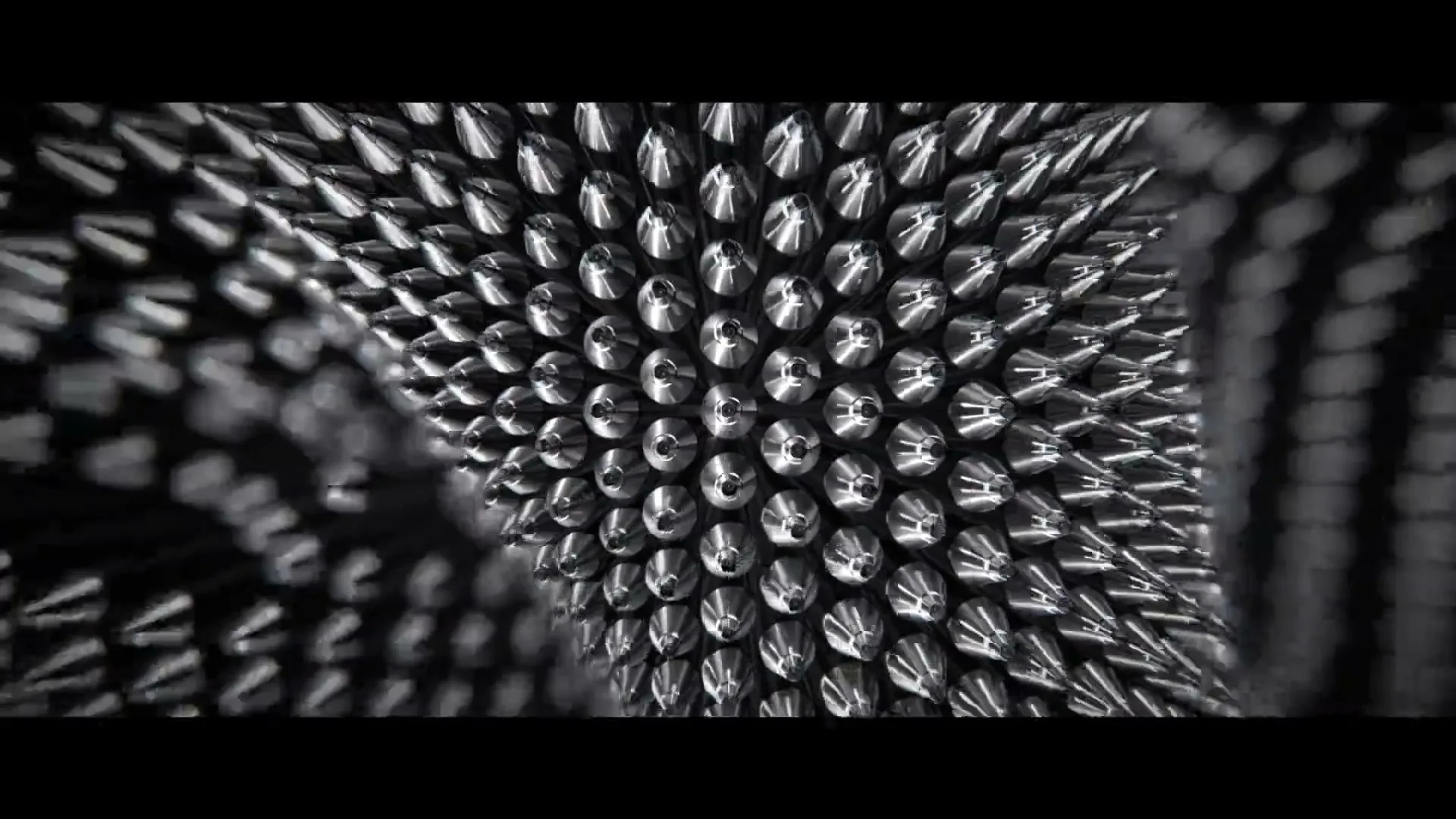 A close-up shot shows a pin art toy forming the shape of a human hand, pushing out from a dark, textured surface.