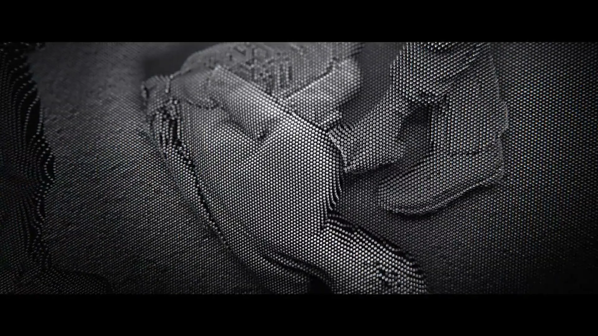 A close-up shot shows a hand pressing against a pin art board, creating a textured, abstract impression in a dark, mysterious setting.