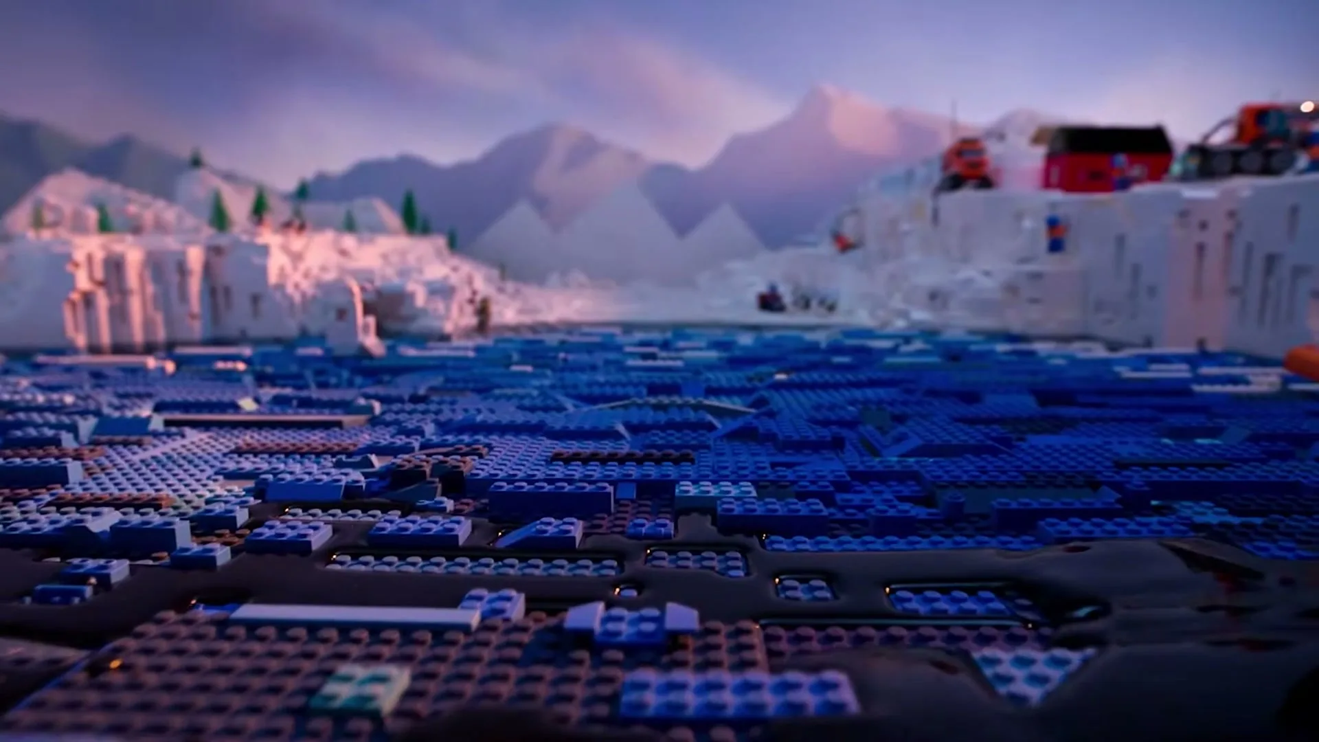 A wide shot of a Lego Arctic landscape shows blue Lego bricks floating in black liquid, with Lego icebergs and mountains in the background under a pink and purple sky.