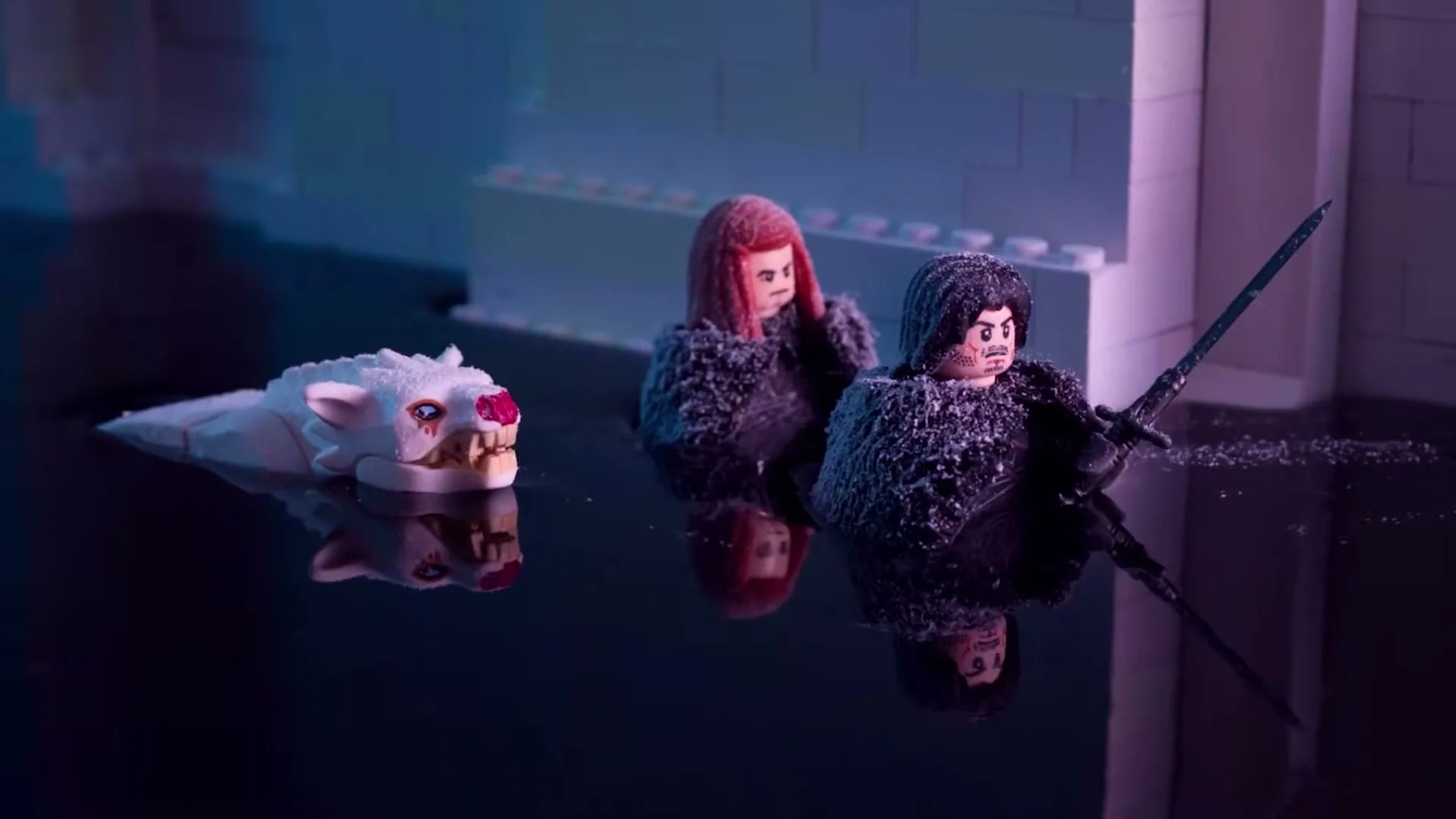 Two Lego figures, one with red hair and one with dark hair holding a sword, are partially submerged in dark water next to a white Lego wolf head.