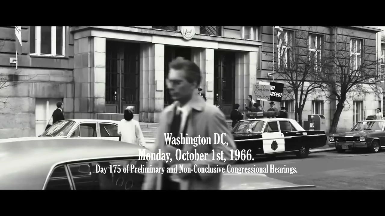 A black and white shot shows a man in a trench coat walking past a government building with cars and people on the street, with text overlay.