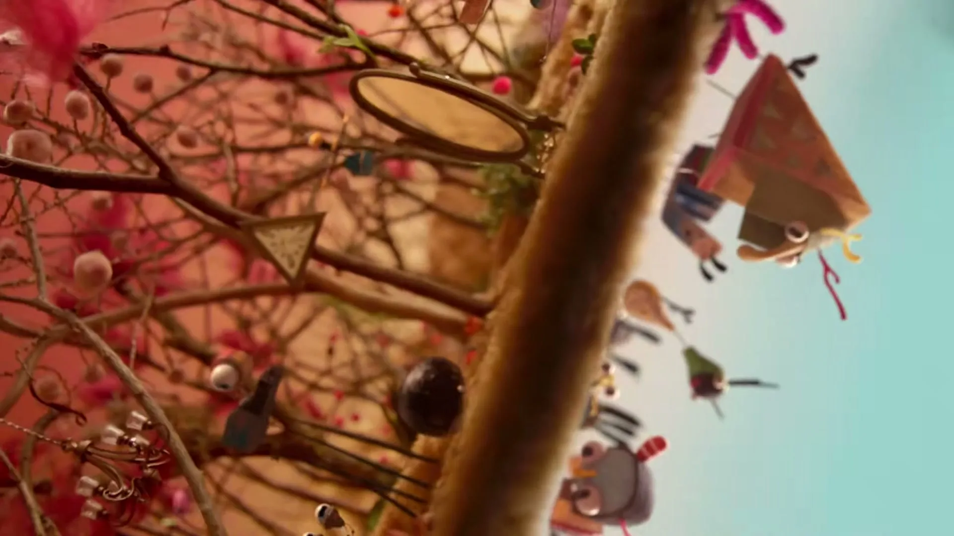 A stop-motion animated boy walks through a whimsical forest with various creatures and objects, as the camera rotates and tilts.