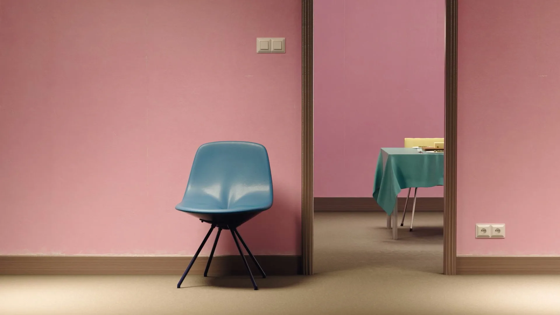 A blue chair sits in a pink room, with a glimpse into another pink room with a table and teal tablecloth through a doorway.