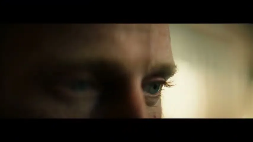 A man's blue eyes are shown in a close-up, looking intently to the right side of the frame, with a blurred background.