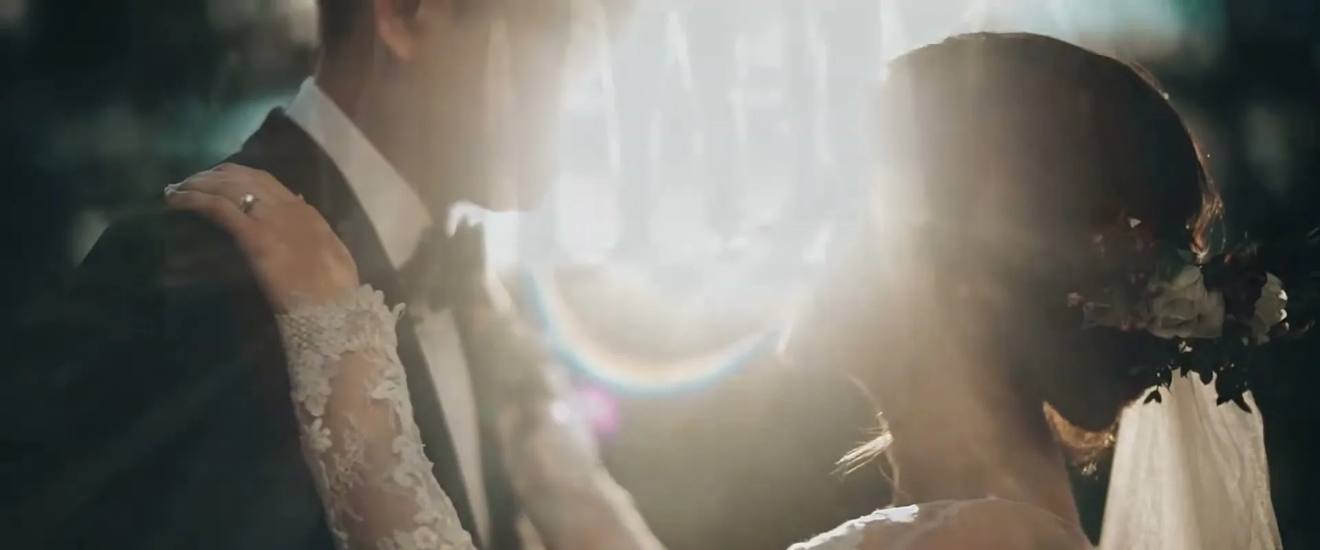 A bride and groom embrace, with the sun flaring brightly behind them, creating a romantic and ethereal glow.