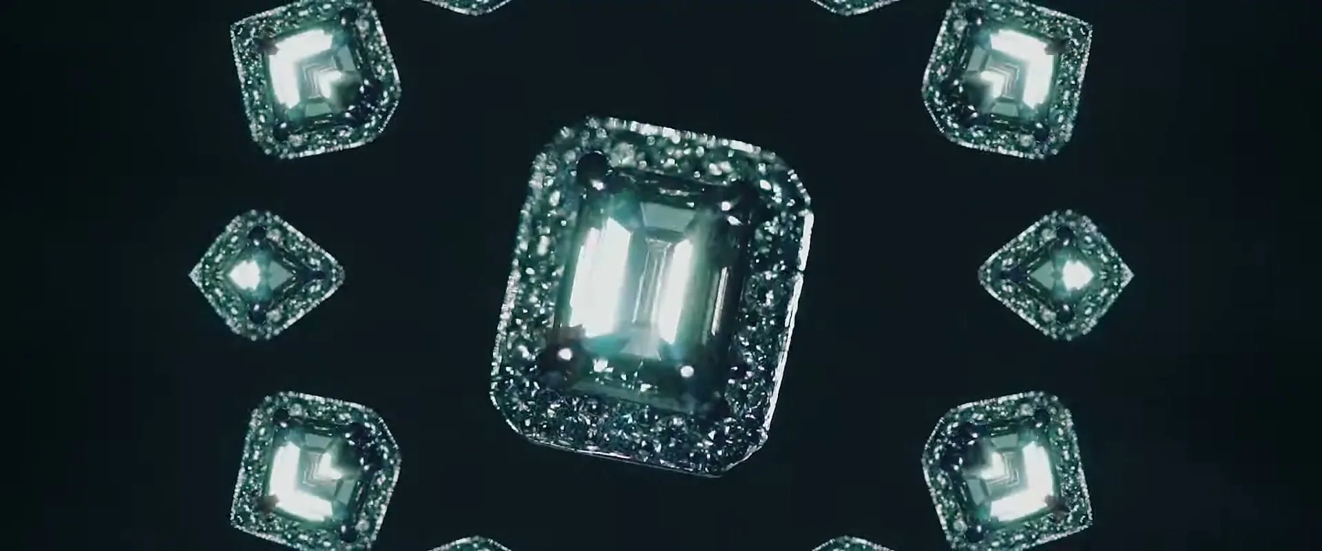 A sparkling diamond ring is centered on a dark background, surrounded by smaller, mirrored versions of itself, creating a kaleidoscopic effect.