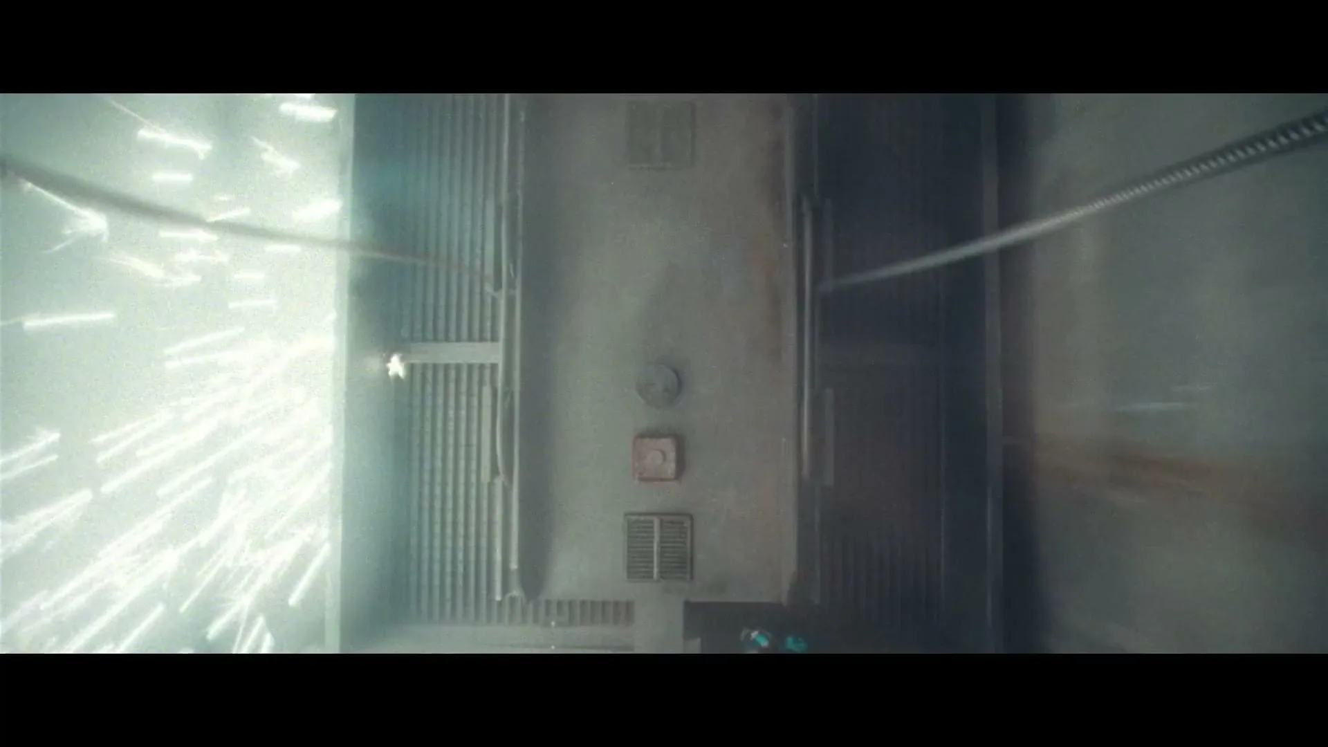 A high-speed shot of an elevator shaft with sparks flying, as if the elevator is rapidly ascending or descending.