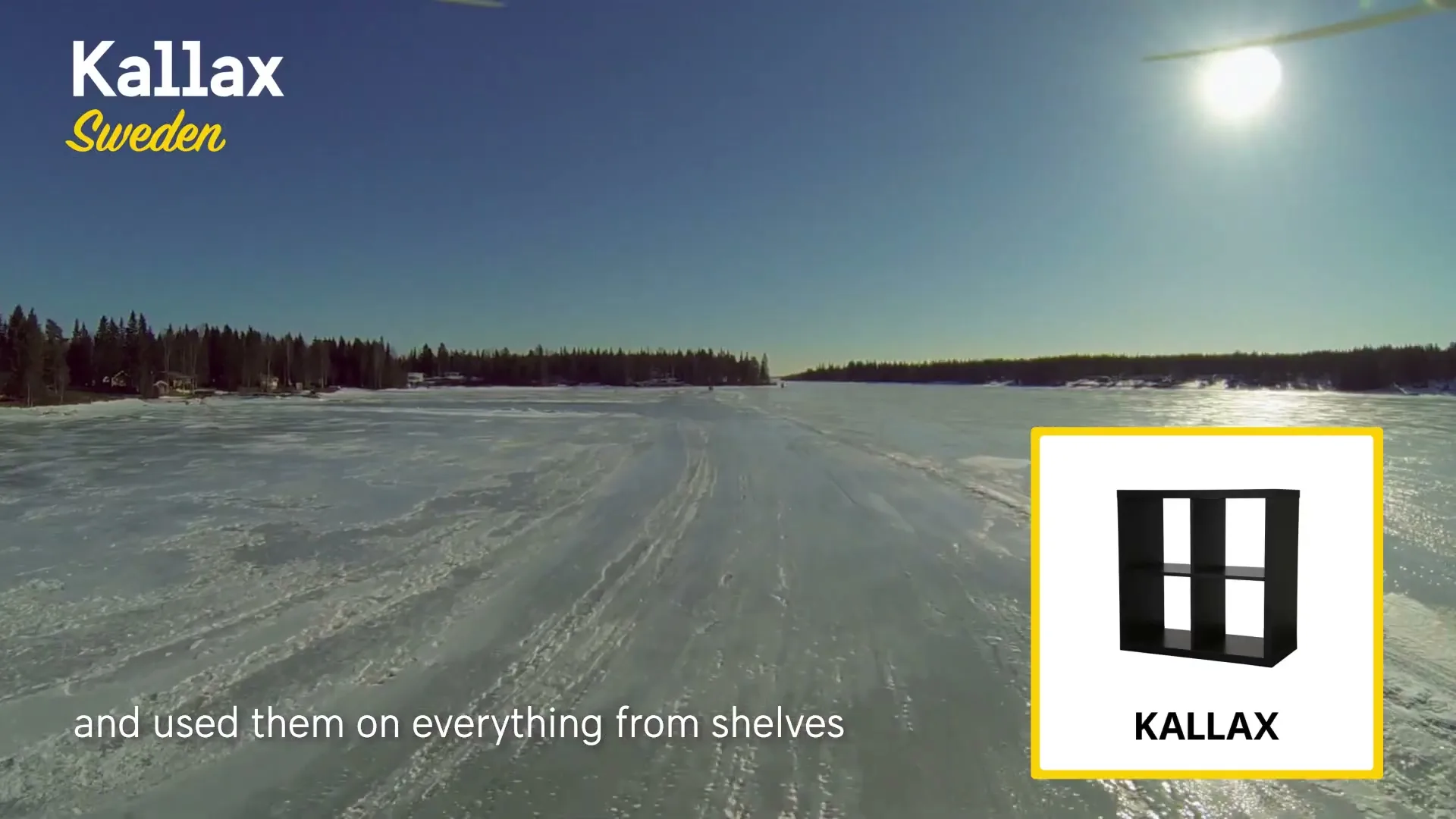 A wide shot of a vast, frozen lake in Sweden under a clear blue sky, with a bright sun and distant trees, featuring a graphic overlay of a black Kallax shelf unit.