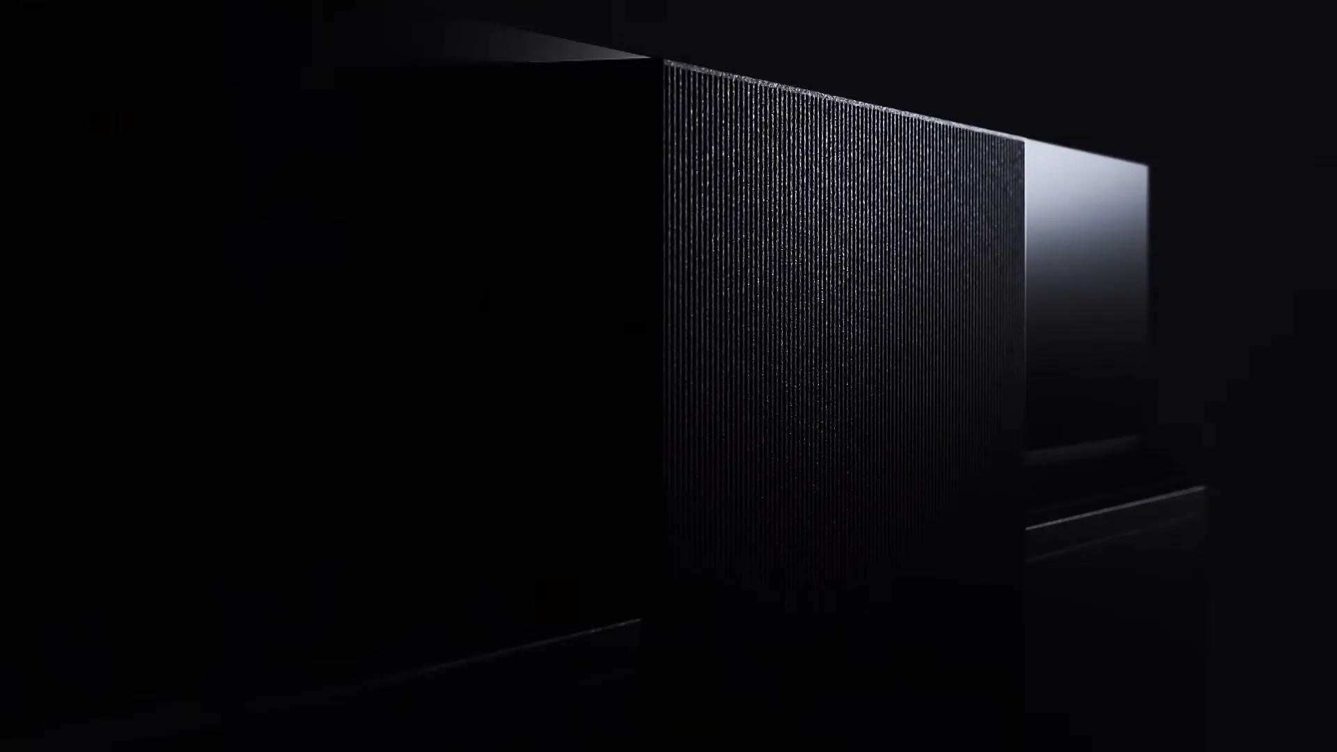 A dark, textured surface with subtle light reflections is shown in a studio setting, emphasizing its sleek design.