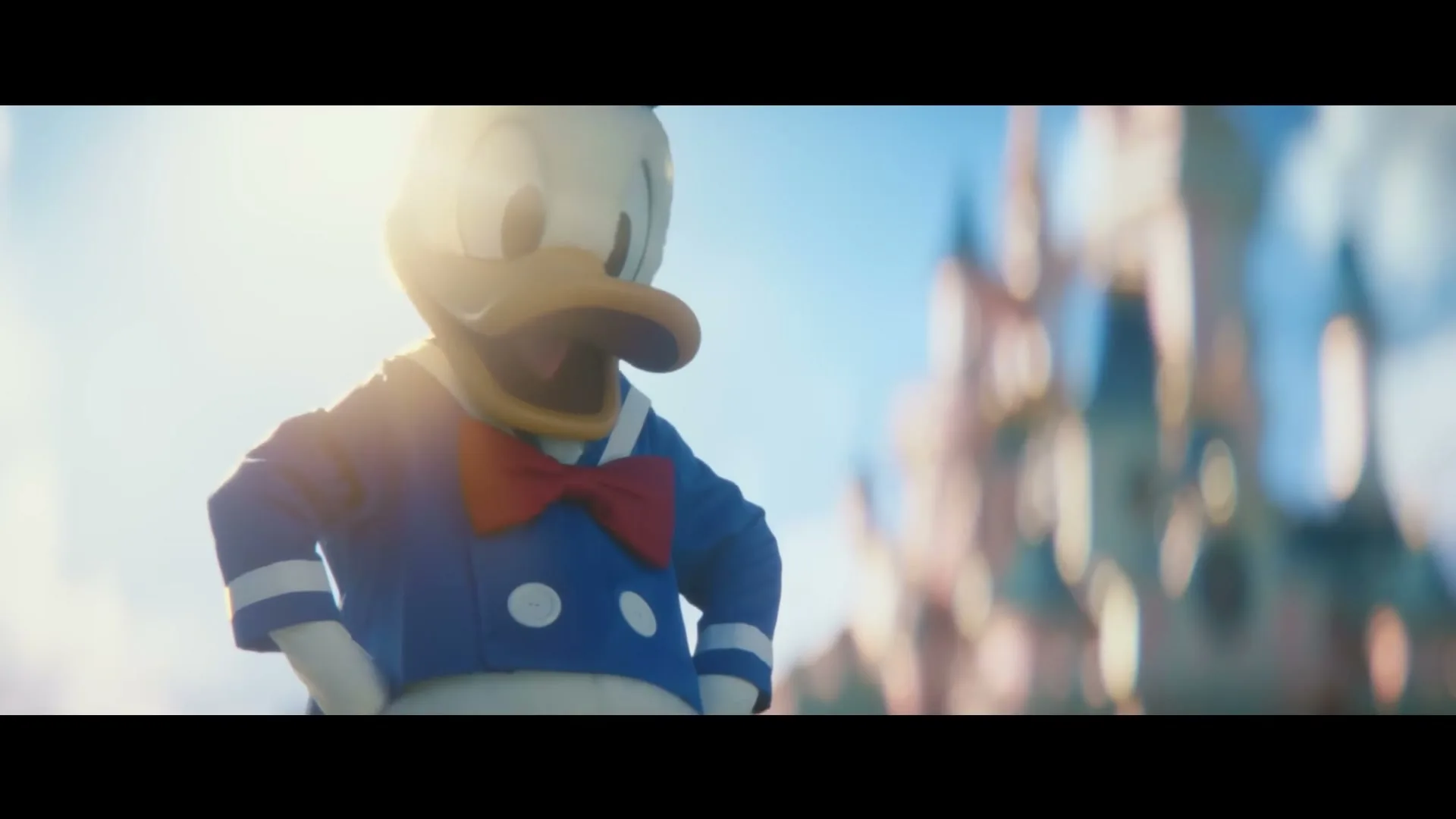 Donald Duck, dressed in his iconic blue sailor suit and red bow tie, stands with hands on hips, looking down at something off-screen, with a blurred castle in the background.