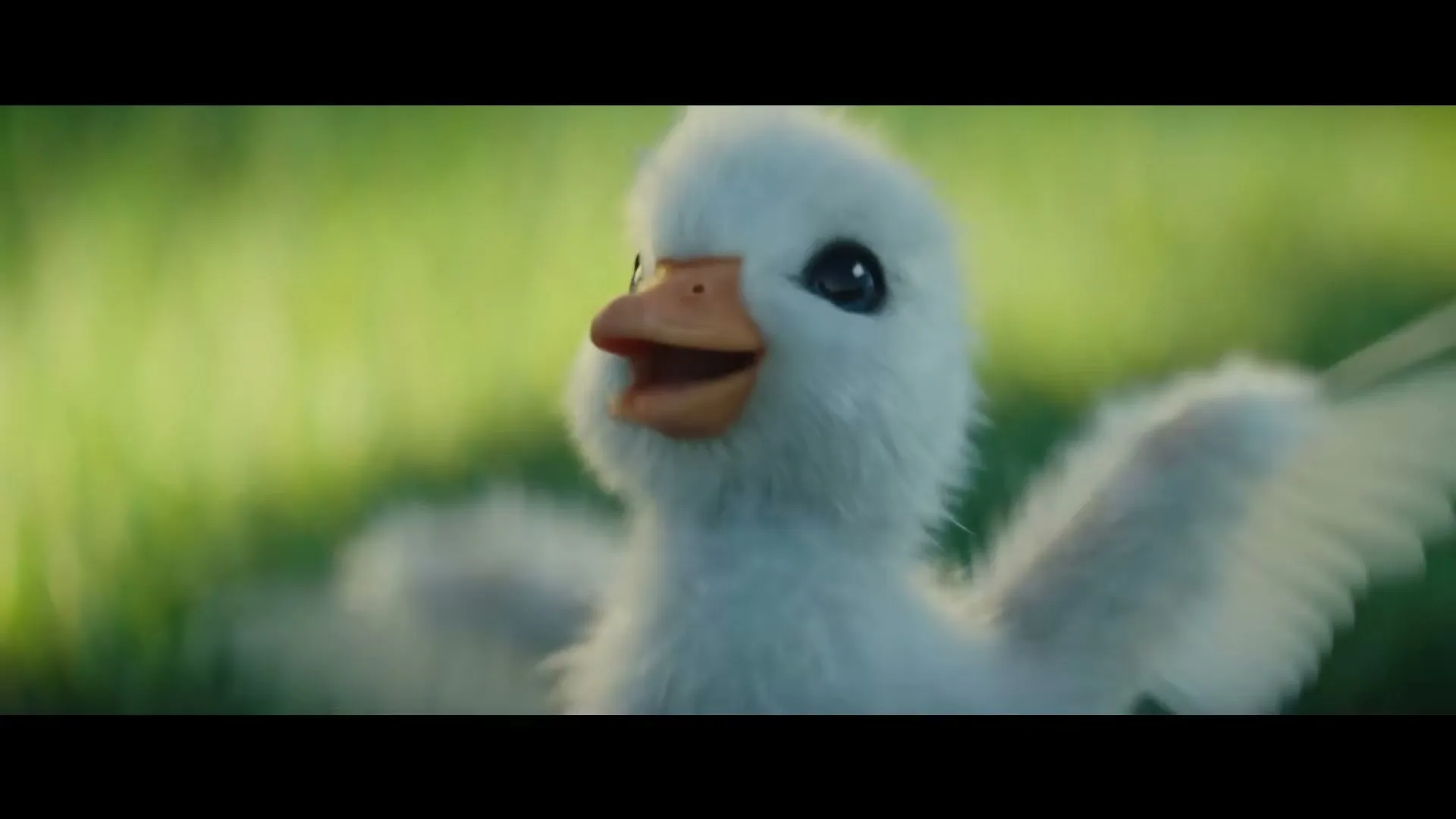 A cute, fluffy white duckling with big blue eyes and an orange beak flaps its wings excitedly in a lush green field.