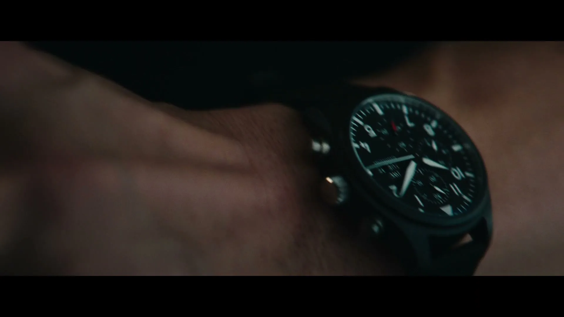 A close-up shot of a person's wrist wearing a black IWC Schaffhausen watch, with the watch face clearly visible.