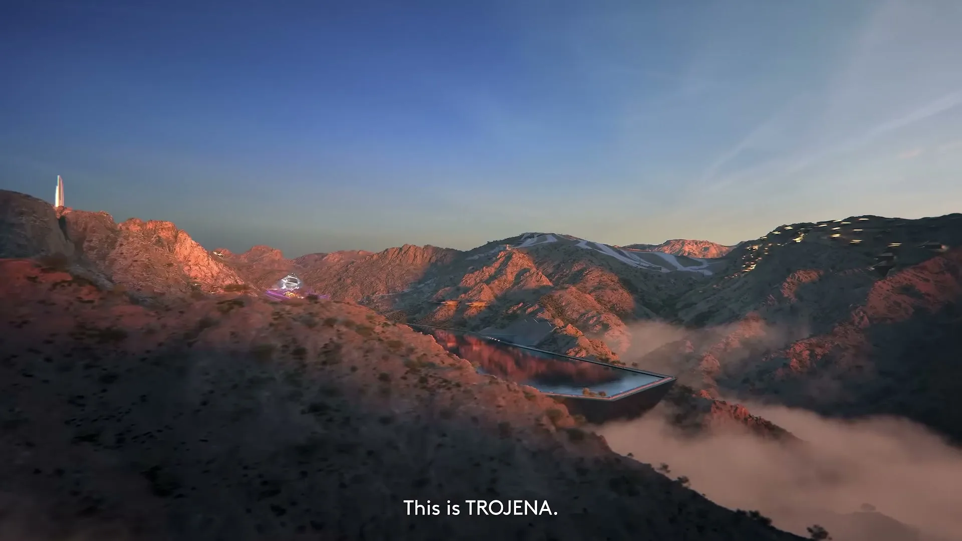 An aerial shot reveals a vast, futuristic mountain resort with a large lake, surrounded by rugged terrain and low-lying clouds at sunset.