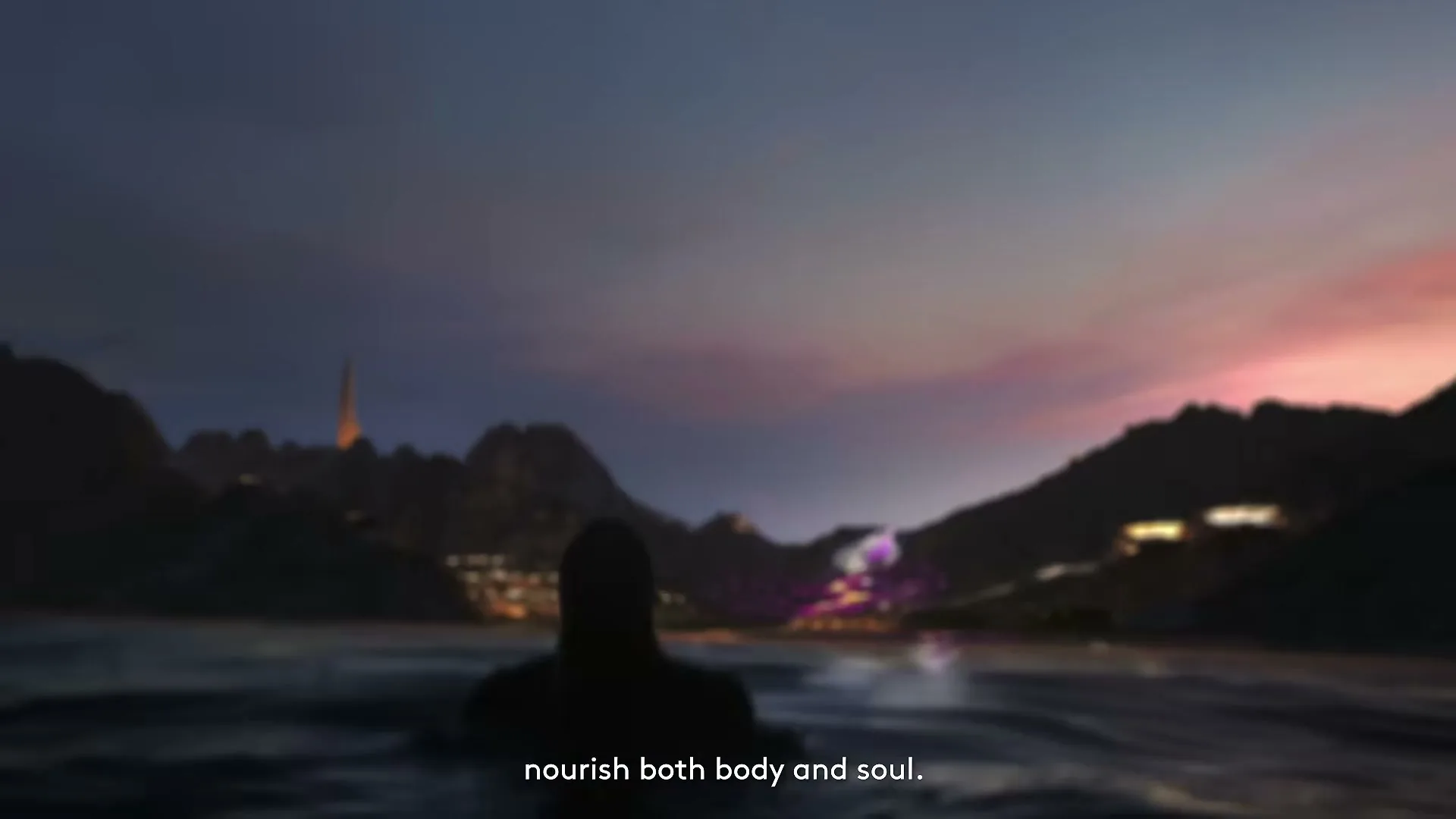 A silhouetted person swims in dark water at dusk, with mountains and city lights in the background.