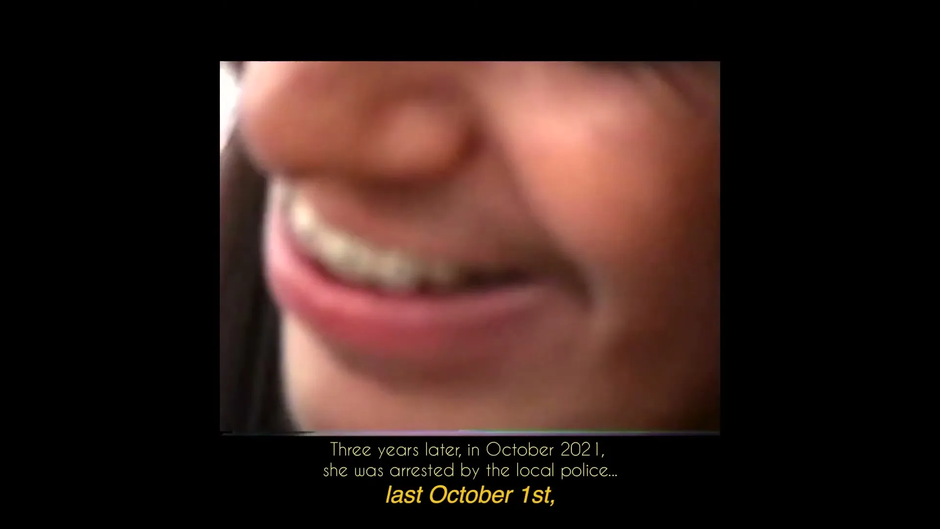 A blurry, extreme closeup of a young person's face, with their mouth slightly open, as text appears on a black background.