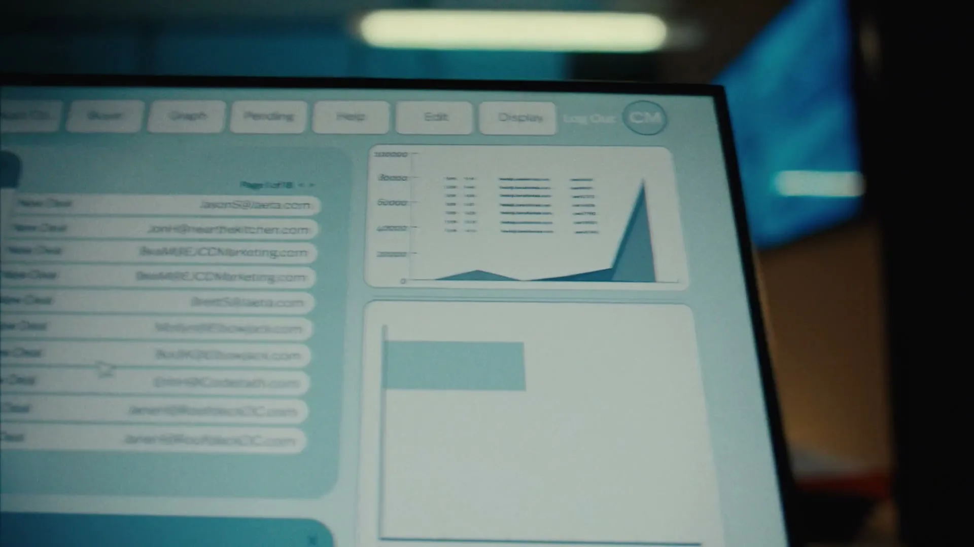 A close-up shot of a computer screen displaying a "Deal Management" interface with various deals, statuses, and contact information, in an office setting.