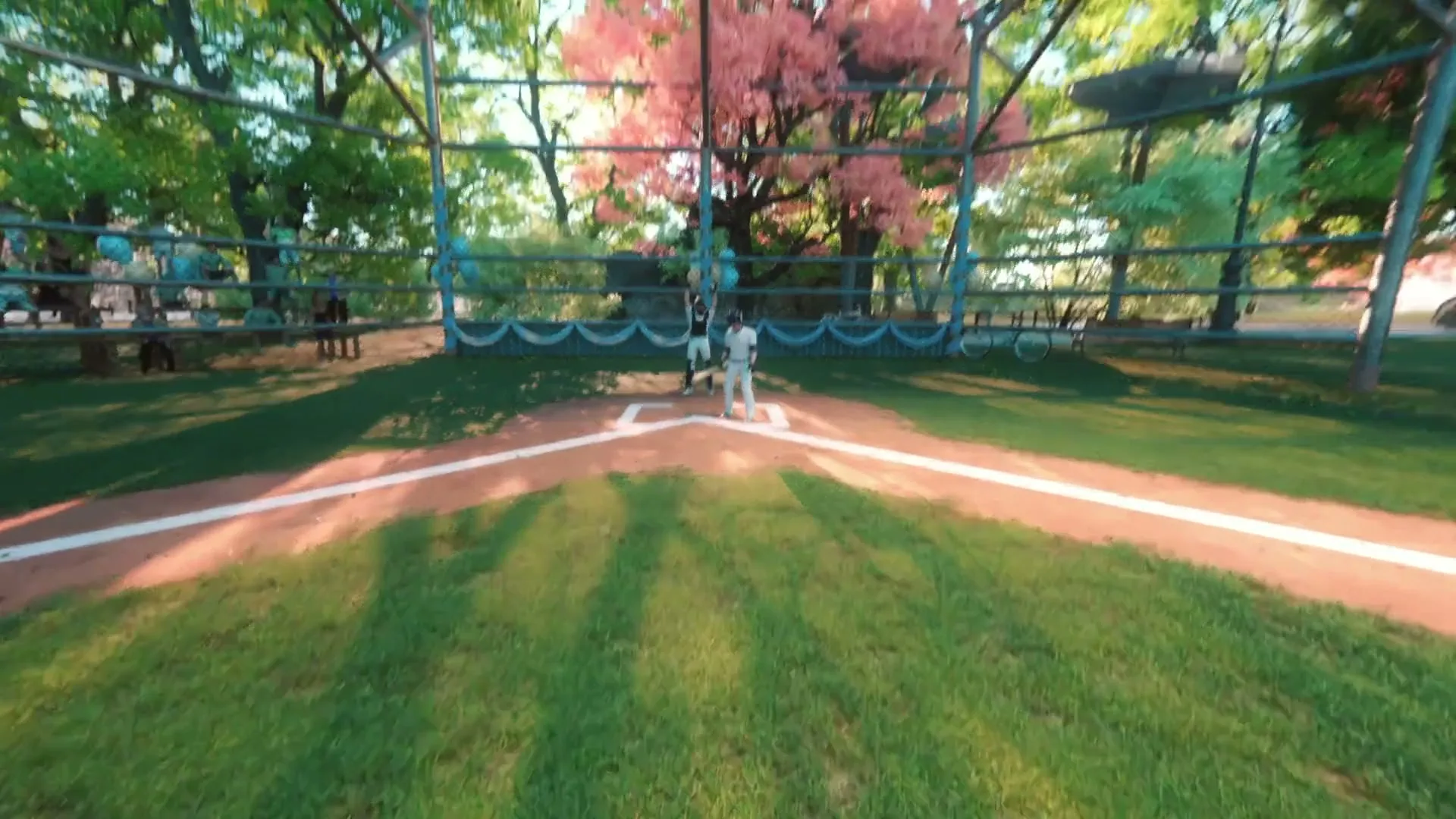 A young woman in a baseball cap and white shirt is seen from a POV shot, hitting a baseball and then celebrating with her arms outstretched on a sunny day.