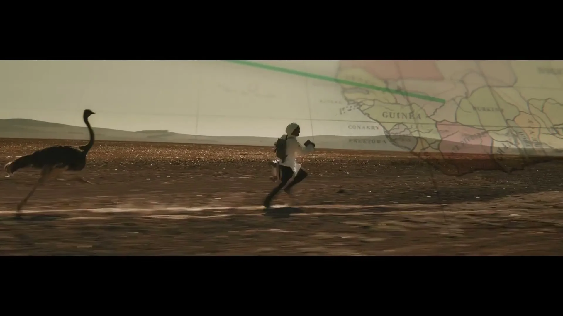A man in a white outfit runs across a desert landscape with an ostrich, as a translucent map of Africa overlays the scene.