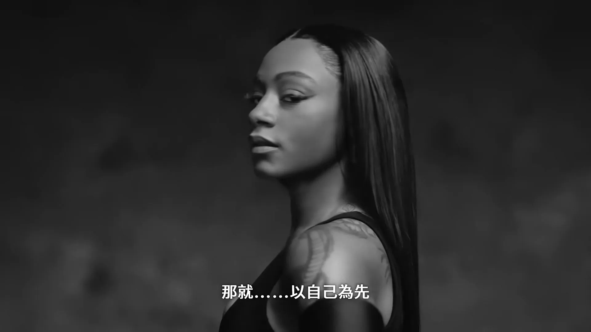 A female basketball player in a white tank top spins a basketball on her finger, then changes into a black sports bra and gloves, looking at the camera in a studio.