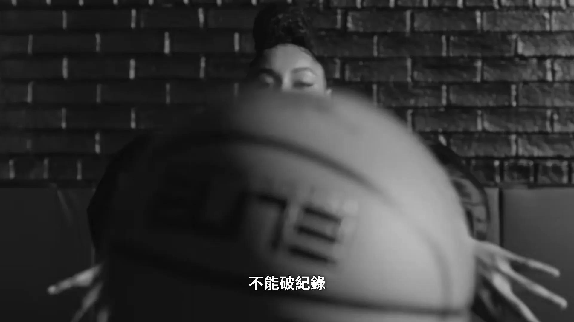 A young female basketball player in a puffy-sleeved top holds a basketball, then shatters a glass barrier in front of her, in a gym.