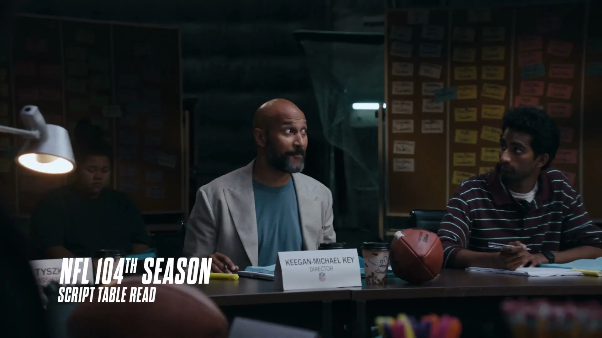 Keegan-Michael Key, a bald man with a beard, sits at a table with two other people during a script reading.