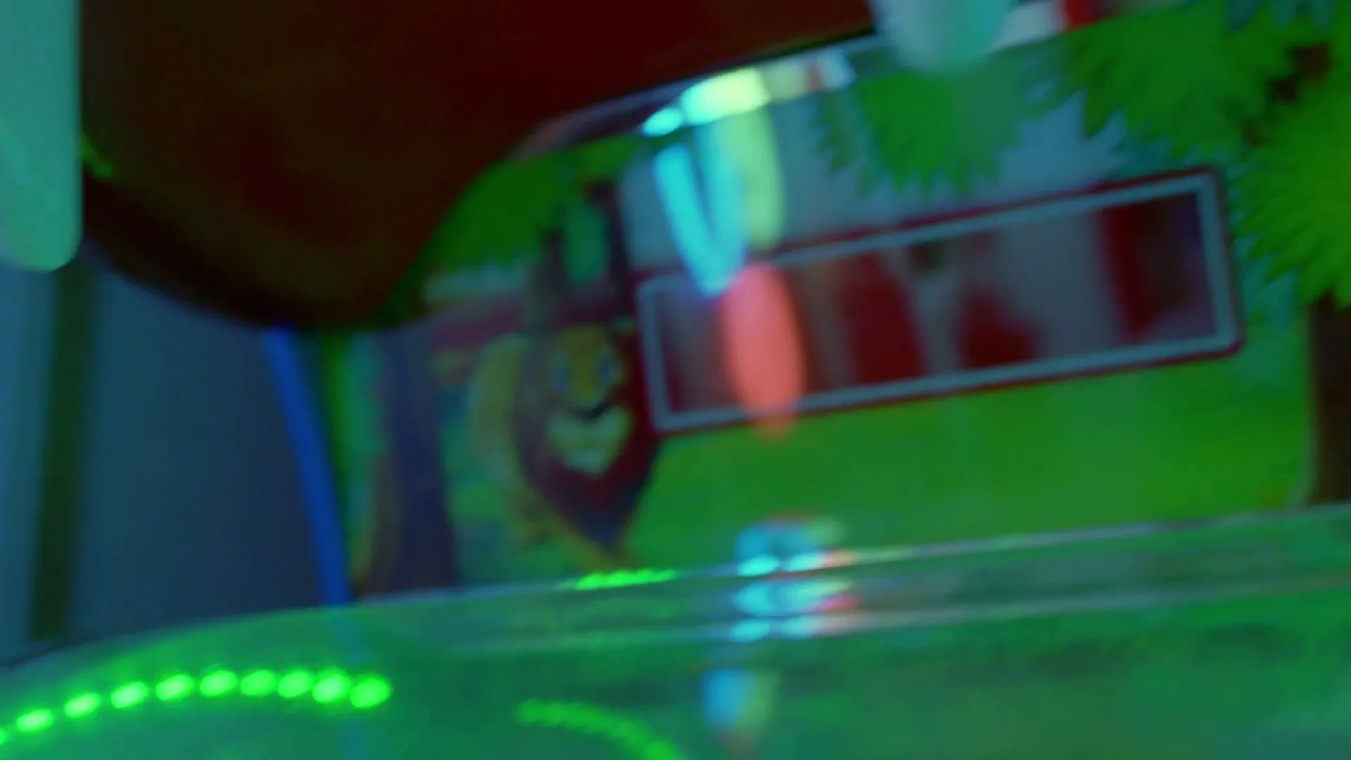 A close-up shot of an arcade game with a lion graphic and flashing lights, showing the text "PULL 1" on its screen.