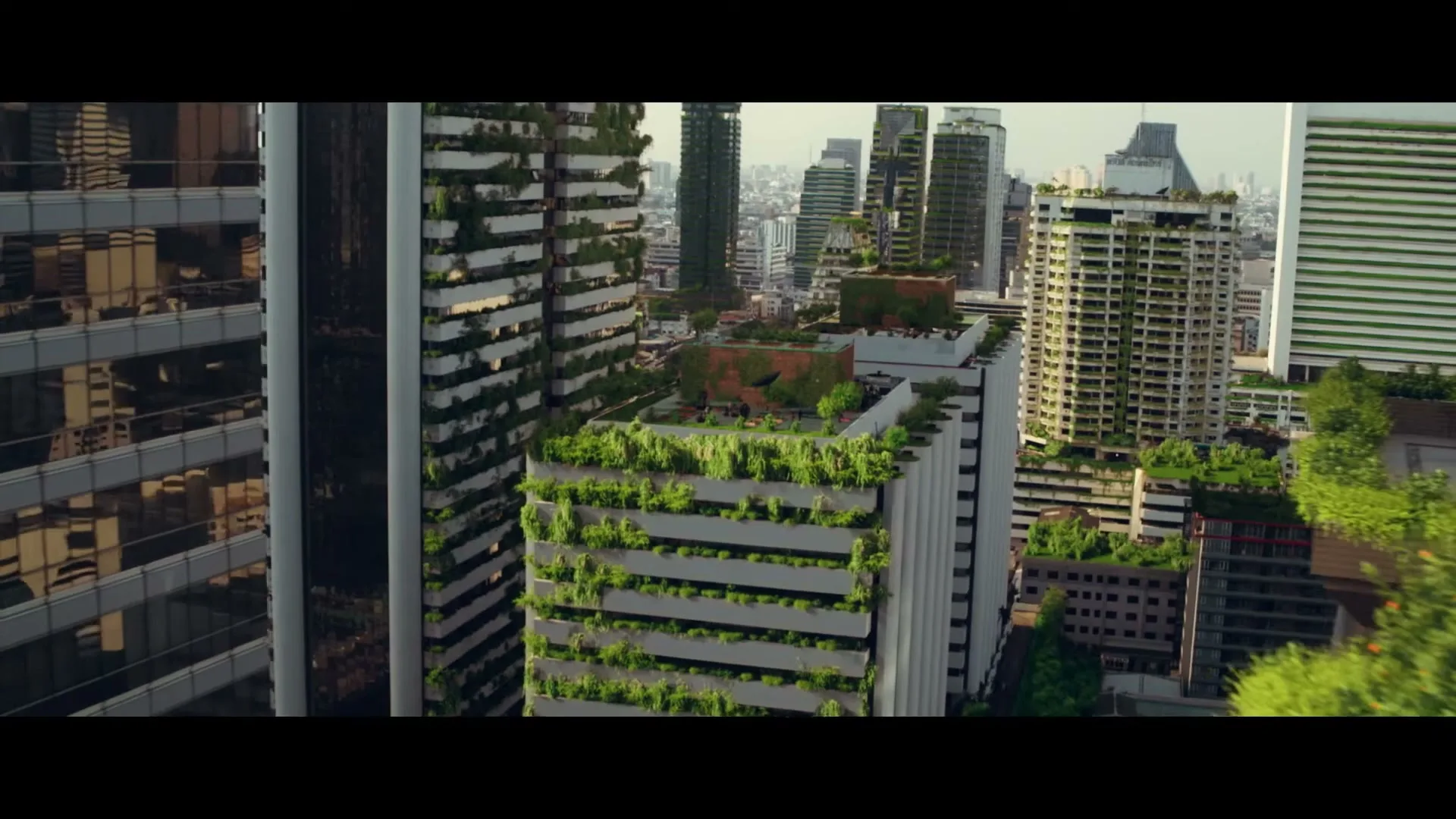 An aerial view of a futuristic city with skyscrapers covered in lush green vegetation, showcasing a harmonious blend of urban and natural elements.