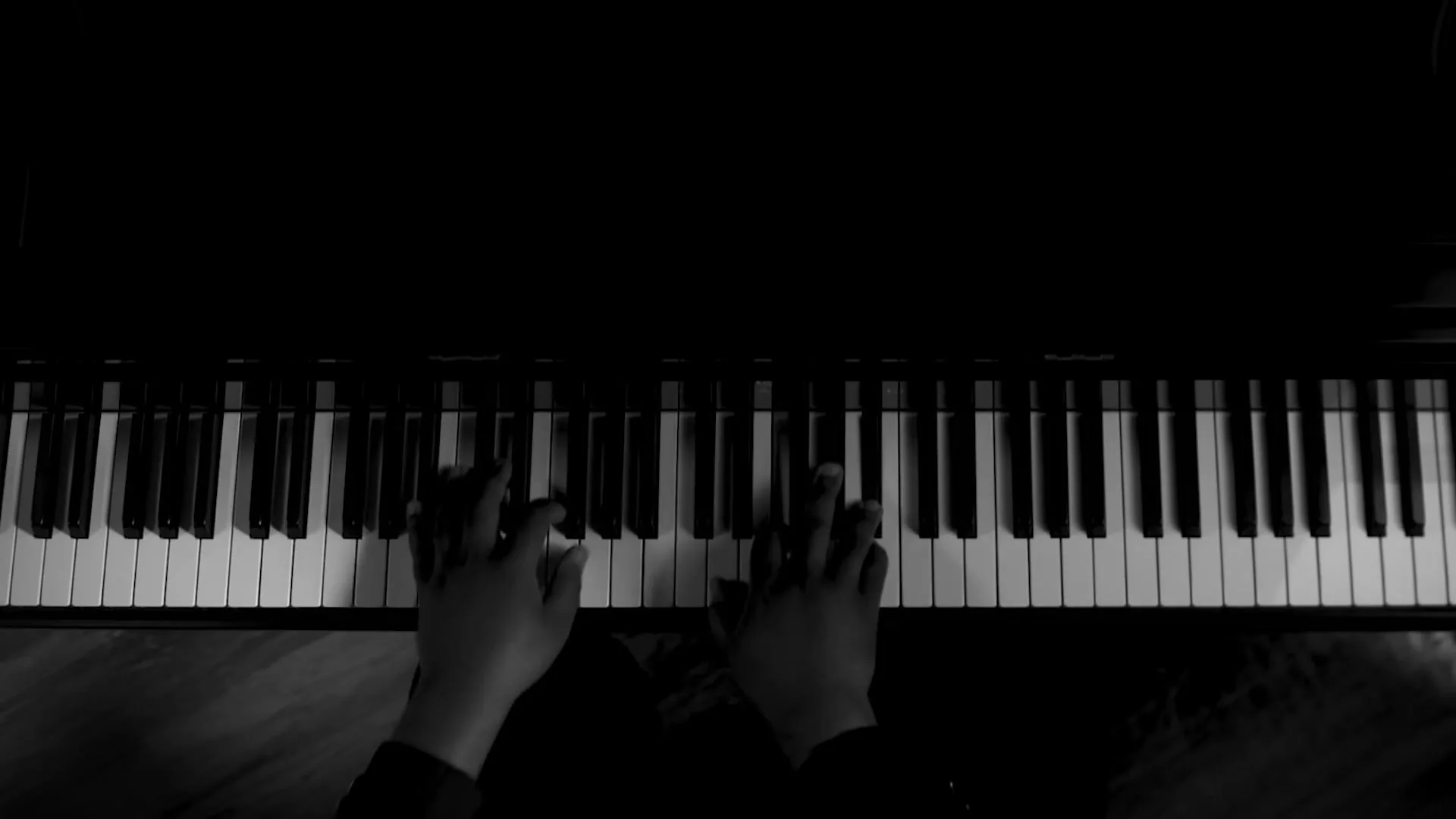 A pair of hands plays "America the Beautiful" on a piano, first using only white keys, then using both black and white keys.