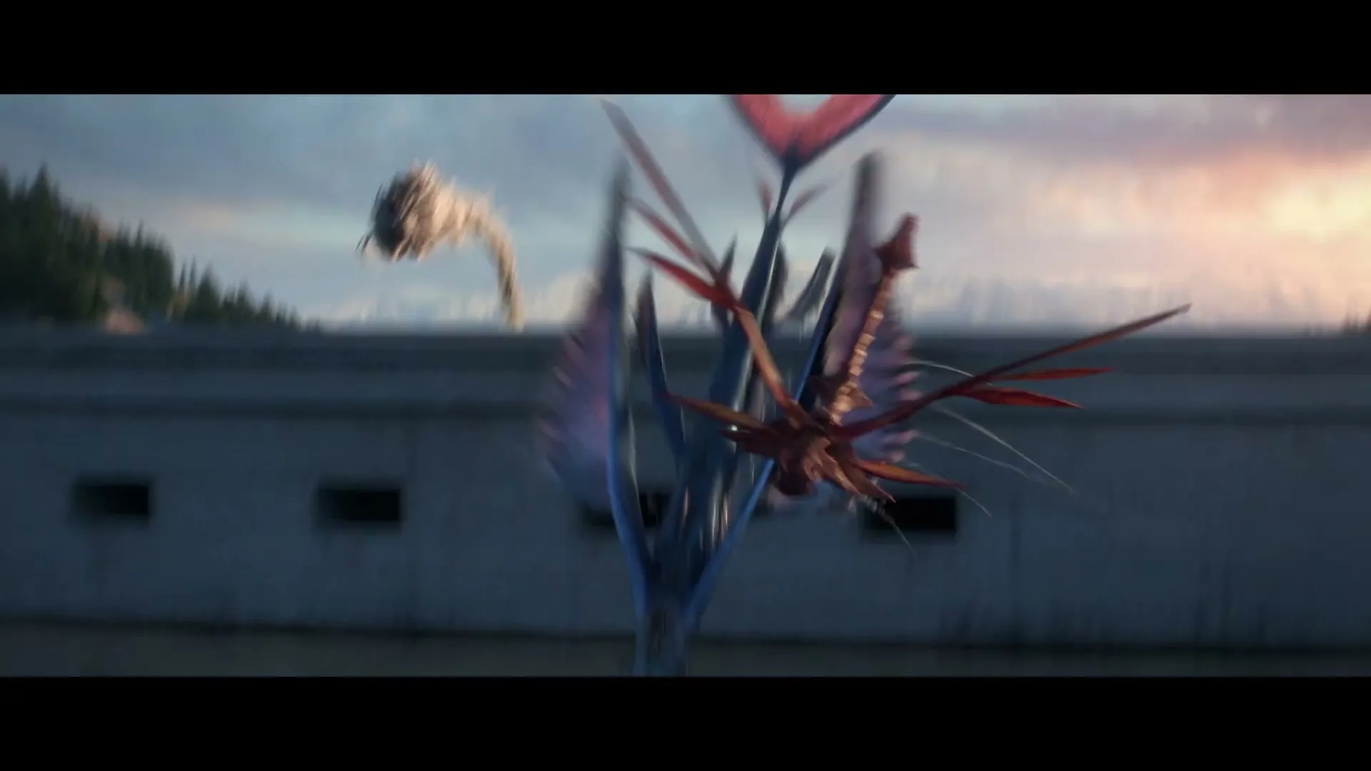 Two fantastical creatures, one blue and one red, fly and crash into a body of water near a concrete structure with mountains in the background.
