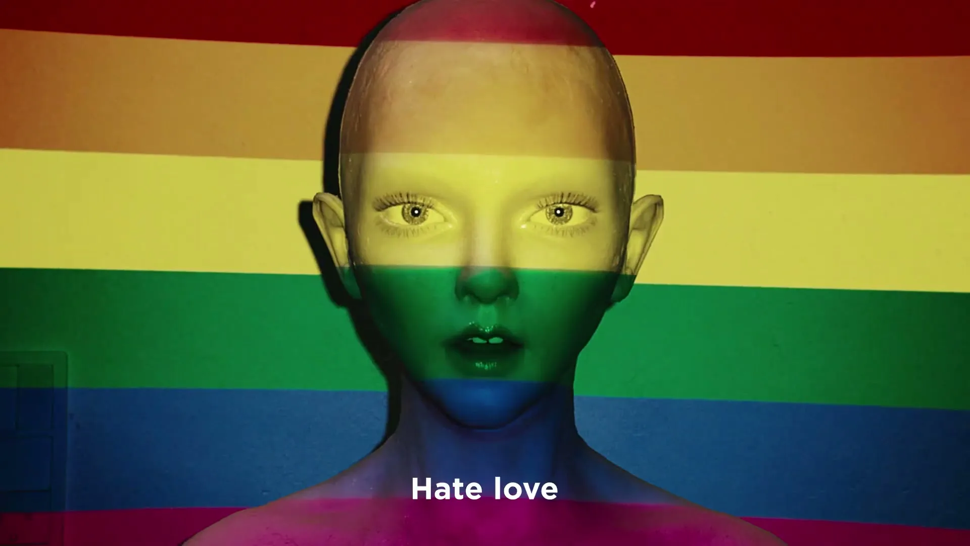 A bald, androgynous person with a rainbow flag projected onto their face and body stares directly at the camera.