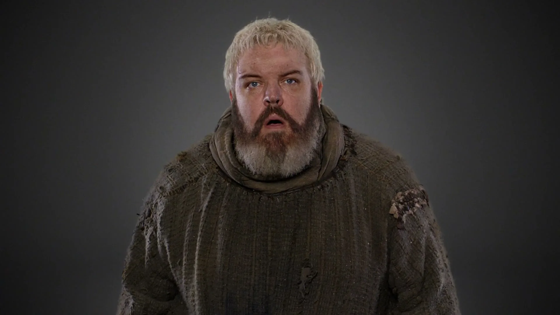 A bald man in a patterned robe transforms into a bearded man in a tattered tunic, both looking surprised against a gray background.