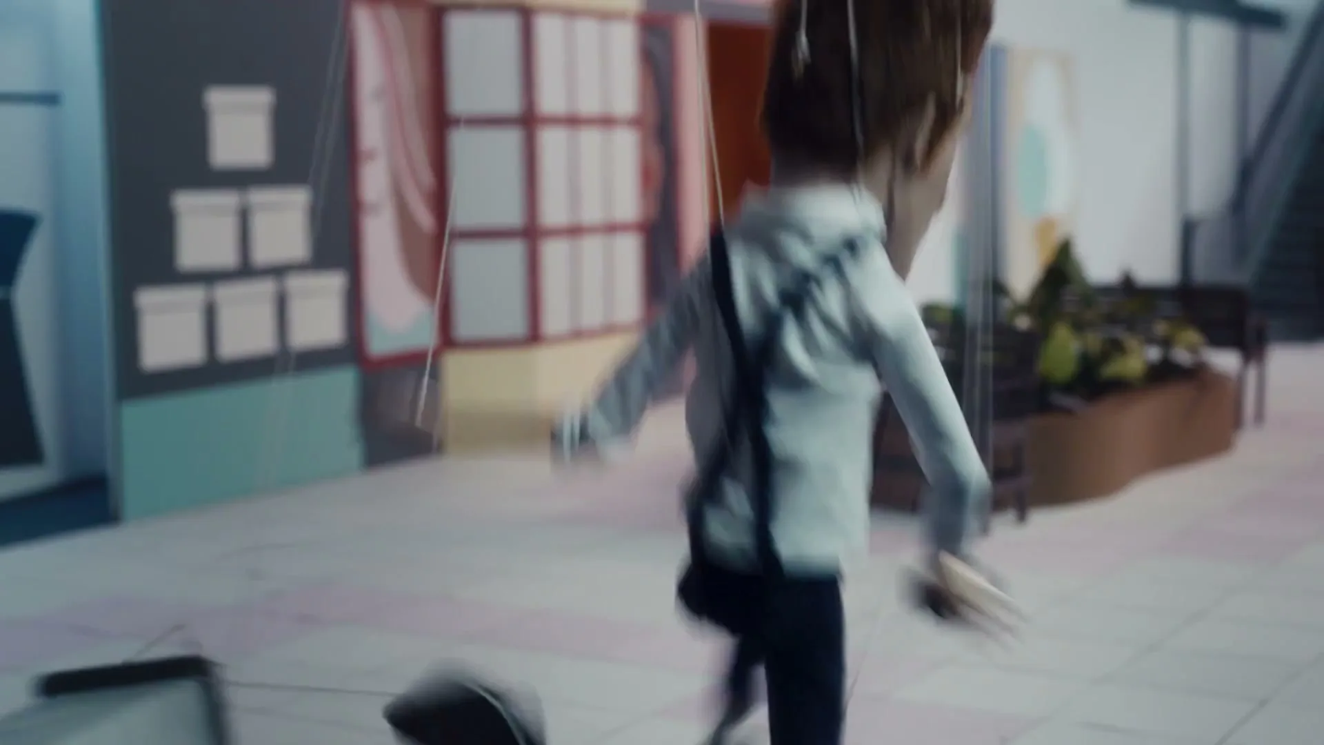 A puppet-like man in a white shirt and suspenders runs through a miniature, stylized shopping mall, pulling a luggage cart behind him.