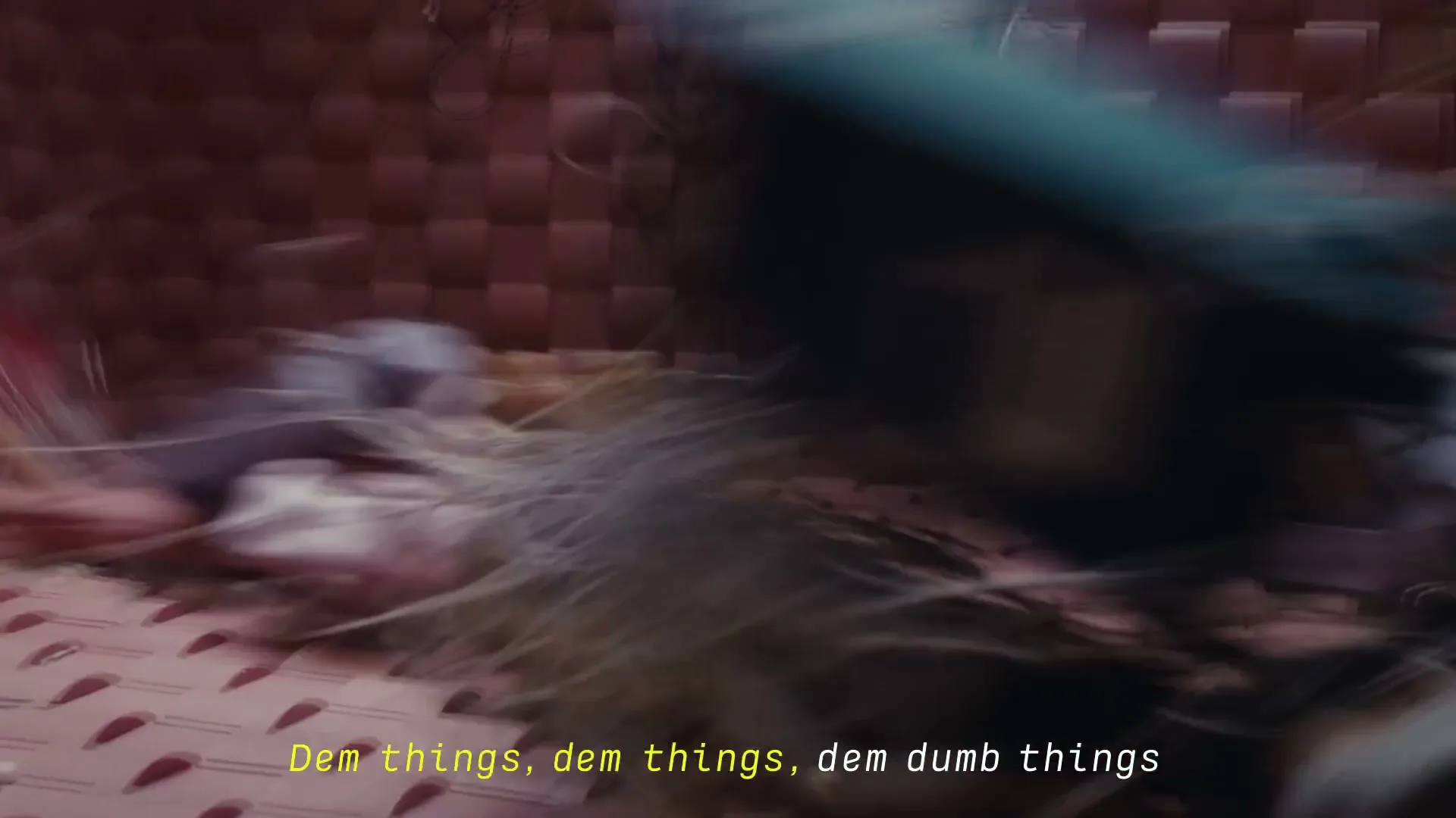 A fast-moving, blurry shot of various objects, including what appears to be a doll, falling into a pink woven basket.