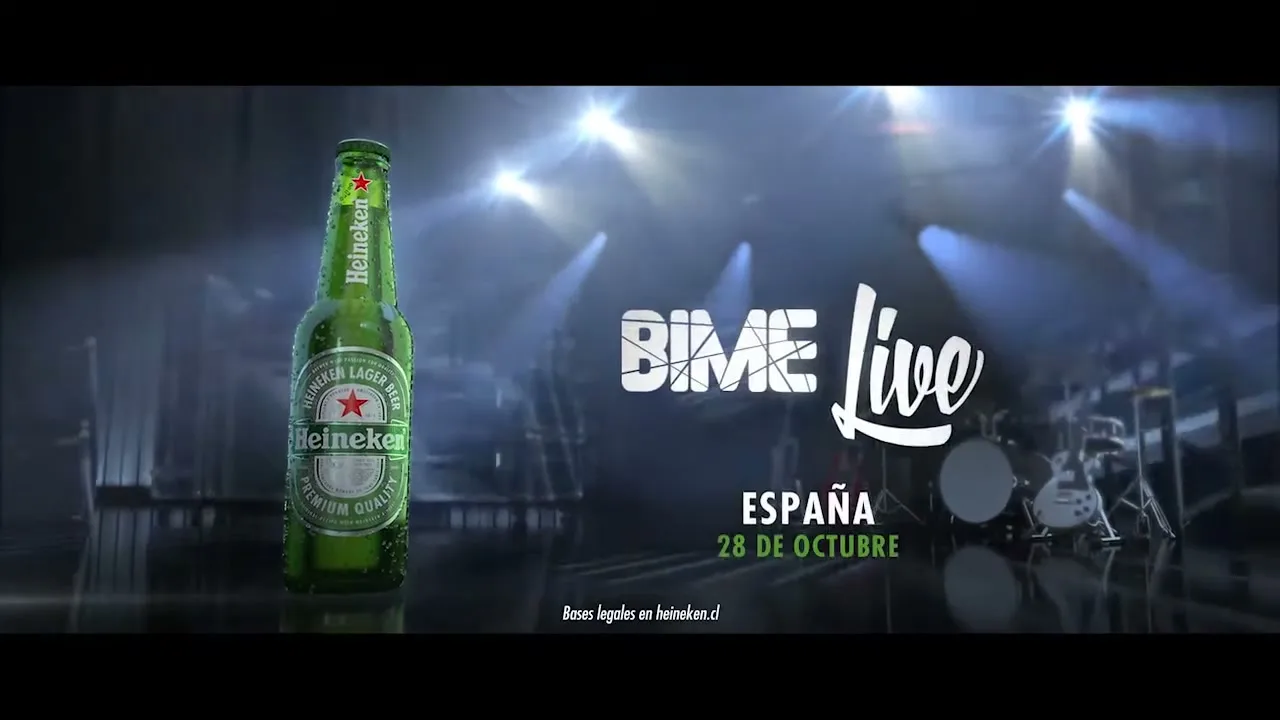 A Heineken beer bottle stands on a reflective stage floor, with bright stage lights and musical instruments in the background, as text about events appears.