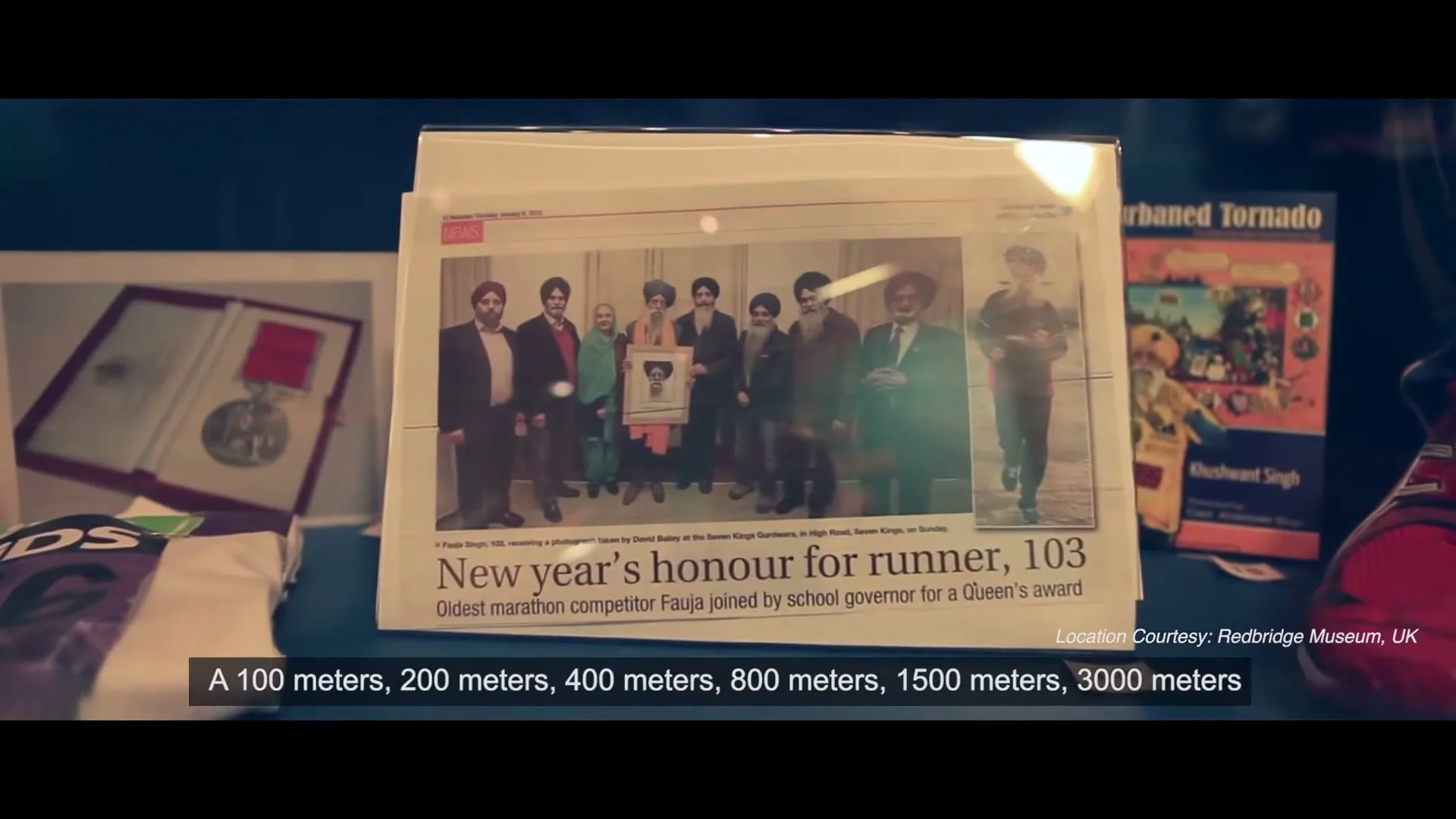 A newspaper clipping about Fauja Singh, the oldest marathon competitor, is displayed among other memorabilia like a medal and running shoes.